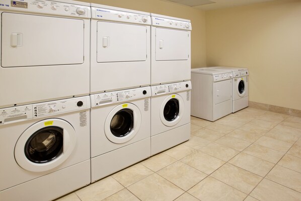A laundry room with multiple washing machines and dryers.