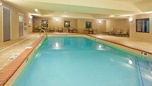 An indoor swimming pool with clear water, numbered lanes, and lounge chairs around the pool. - Accessible Suite | Roll-In Shower | Free Breakfast (Elkhart)
