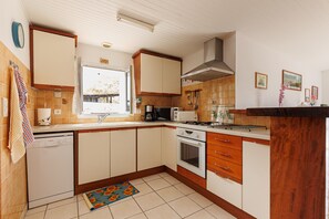 A kitchen with a dishwasher, oven, and a window. - Gîte Chez Françoise et Jean: natural air conditioning in Saint-Lon-les-Mines (Saint-Lon-les-Mines)