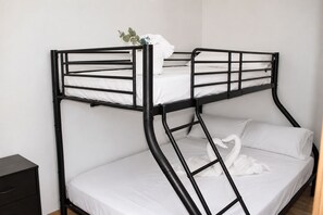 Una cama litera con colchón blanco y estructura metálica negra.