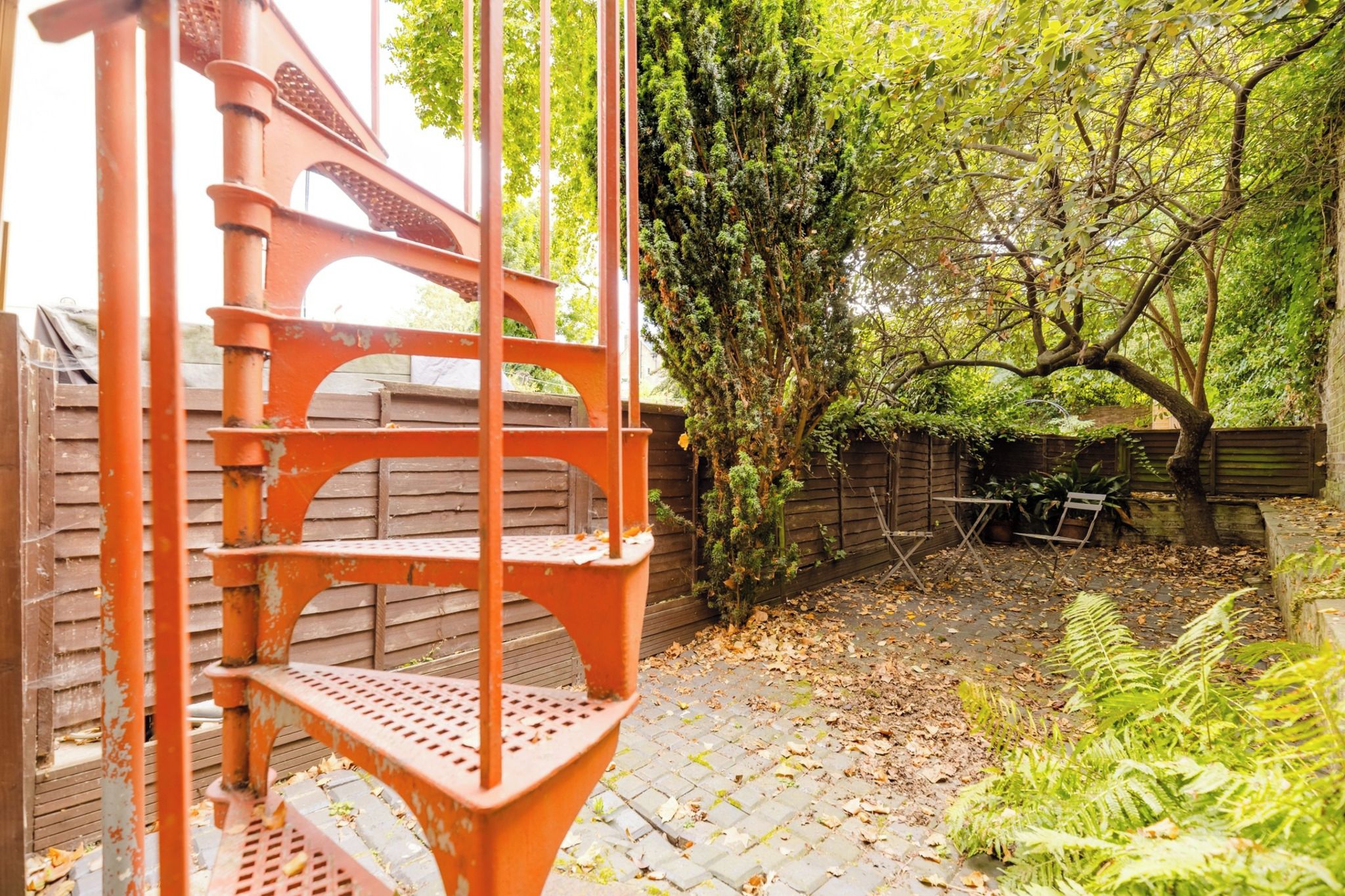 Una escalera de madera con barandilla de metal que da a una terraza de madera.