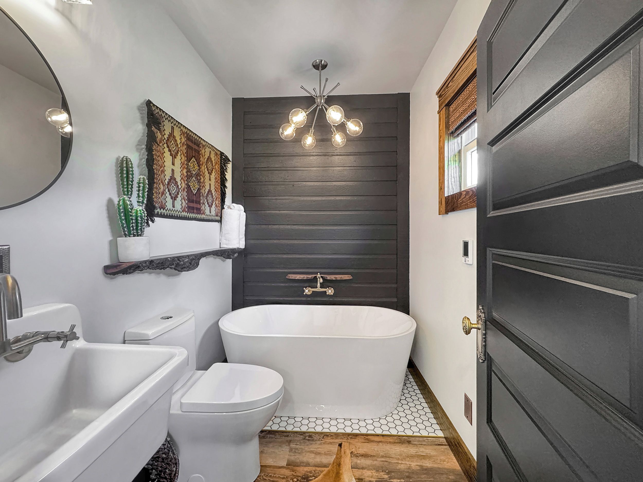 A modern bathroom with a freestanding bathtub, a toilet, and a sink.