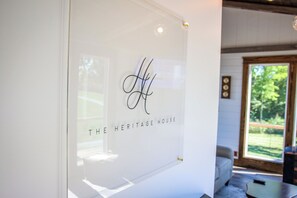A glass wall with a monogram and text indicating 'THE HERITAGE HOUSE'.