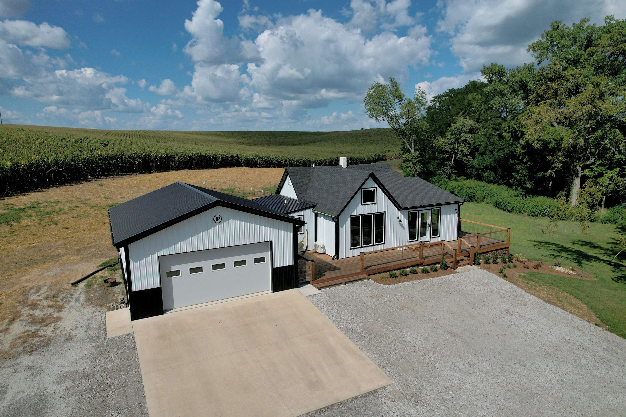 A two-story house with a garage, a deck, and a driveway.