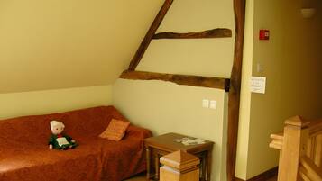 Une pièce chaleureuse avec un banc en bois, une petite table et un canapé agrémenté d’un coussin.
