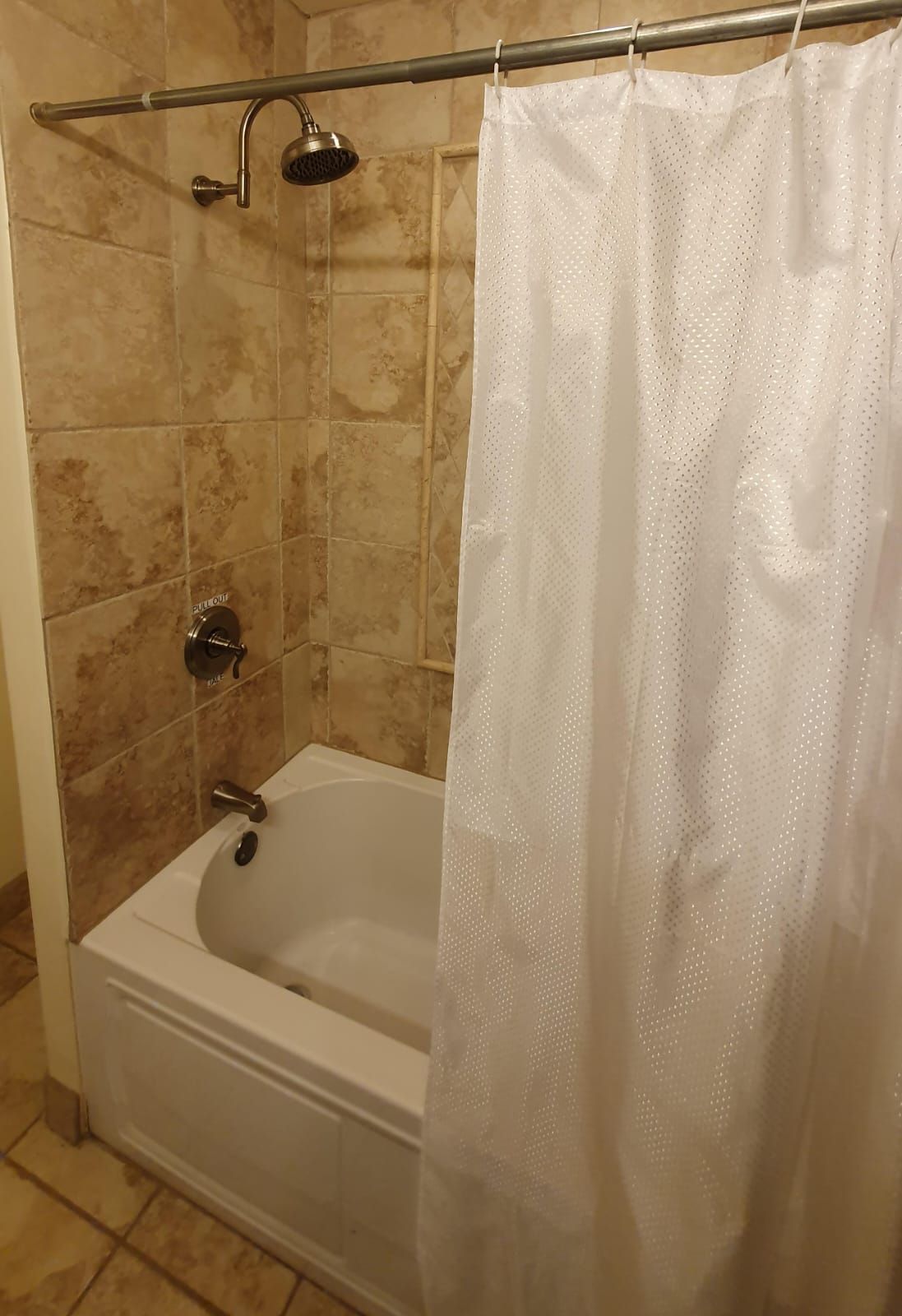 Un baño con bañera, cabezal de ducha y tocador extraíble.