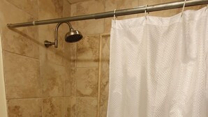 Un baño con bañera, cabezal de ducha y tocador extraíble.