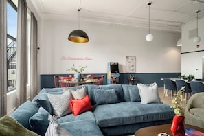 Ein modernes Wohnzimmer mit einem Ecksofa, einem Couchtisch und einer roten Vase.
