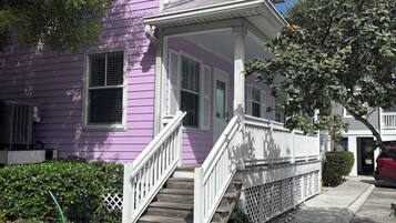 A two-story house with a porch, a staircase, and a driveway.