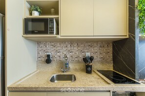 A kitchen with a microwave, sink, and stove. - Studio in Building With Pool in Salvador Hfo0203 (Salvador)