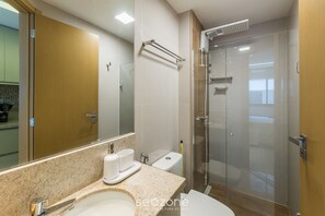A modern bathroom with a glass shower enclosure, a sink with a marble countertop, and a toilet. - Studio in Building With Pool in Salvador Hfo0203 (Salvador)