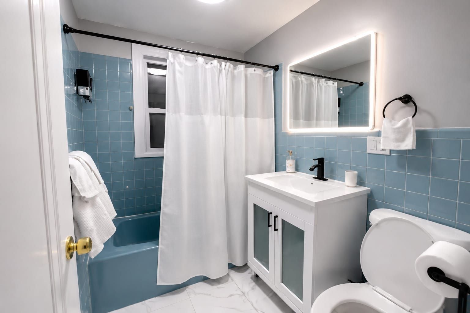 A bathroom with a bathtub, a sink, a toilet, and a shower curtain.