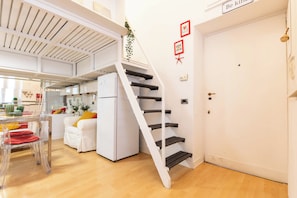 A modern interior with a staircase, a dining area, and a kitchen. - Casa Orione – Cozy Loft on the Navigli (Milano)
