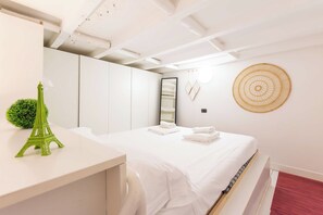 Ein Hotelzimmer mit einem Bett, einem Schreibtisch, einem Spiegel und einer Wanddekoration.