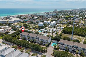 Zona residencial a la costa amb un hotel gran que té edificis de diversos pisos, una piscina i vistes a l'oceà.