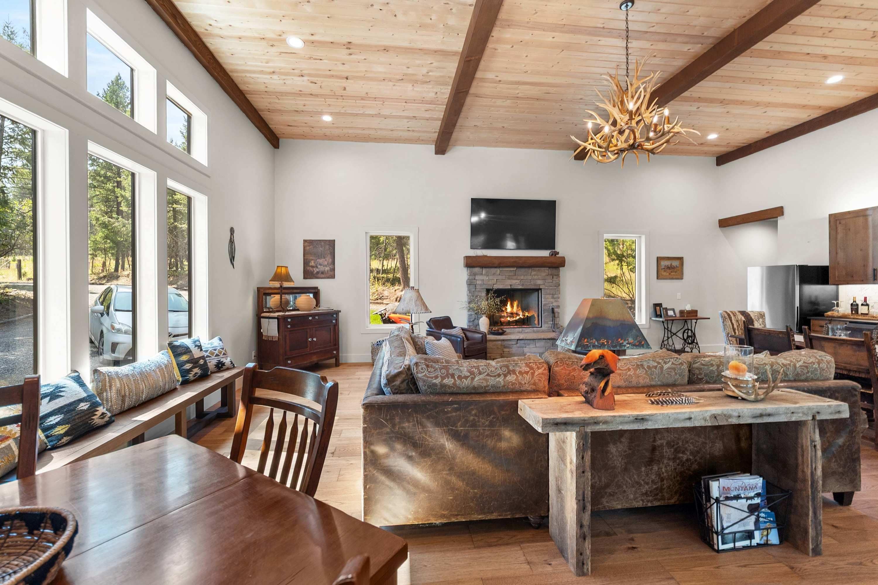 A spacious living area with a stone fireplace, a large sofa, and a dining table.