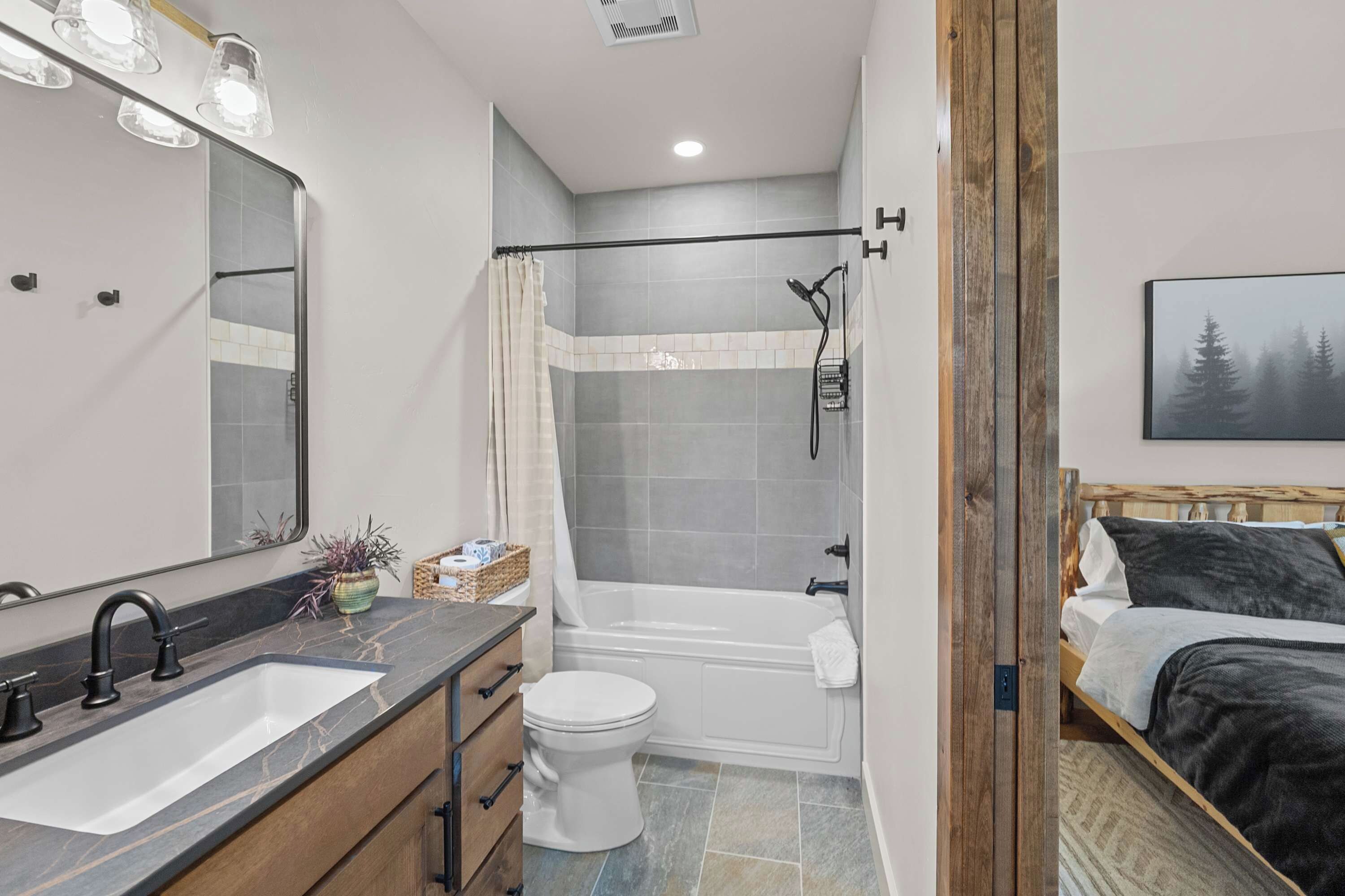 A modern bathroom with a shower, toilet, and sink.