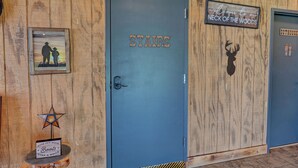 A wooden wall with three doors labeled 'STARS,' 'NECK OF THE WOODS,' and 'OUTHOUSE.' - Rustic-Chic Barn with 4-Private Suites, 3-upstairs BR's made for Family memories (Montgomery)