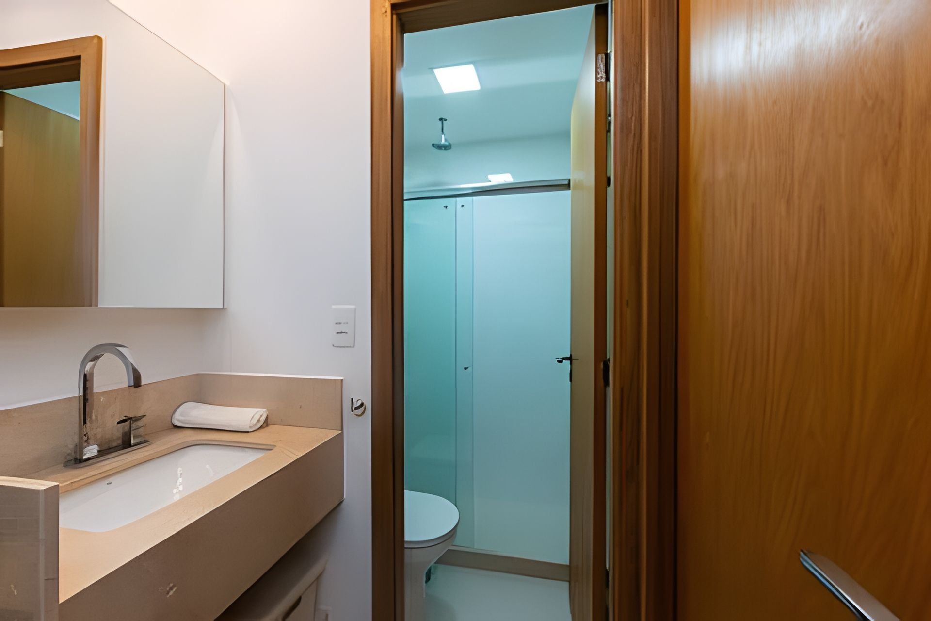 Un baño con lavamanos, espejo e inodoro.