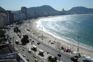 A coastal cityscape with a wide beach, high-rise buildings, and a clear sky. - BR668 (Rio de Janeiro)