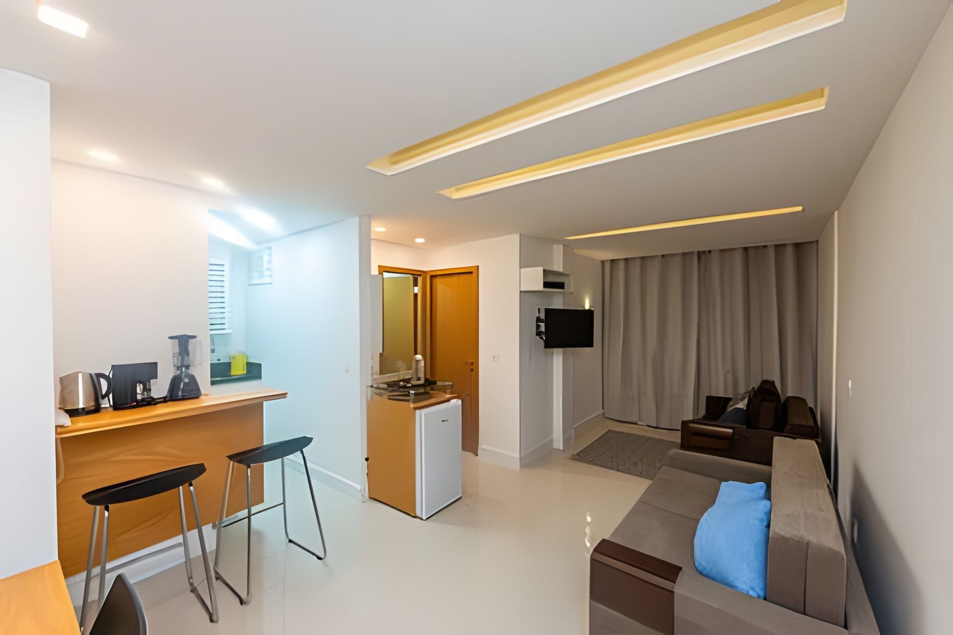 Una sala de estar moderna con un sofá, una mesa de centro y un televisor montado en la pared.