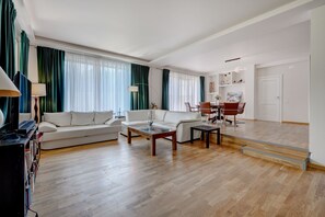 Ett rymligt vardagsrum med en soffa, ett soffbord och en matplats.