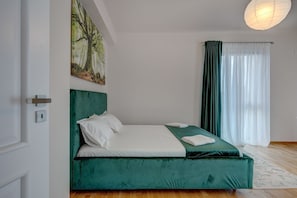 Una camera da letto con un letto, un quadro, una finestra con tende e una porta.