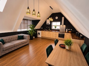 A modern loft apartment with a dining area, kitchen, and living space. - 4 Bedroom Luxury Apartment in Rushden (Rushden)
