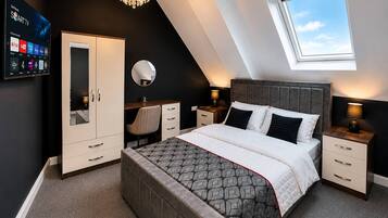 Un dormitorio moderno con cama, mesitas de noche, armario, escritorio, espejo y candelabro.