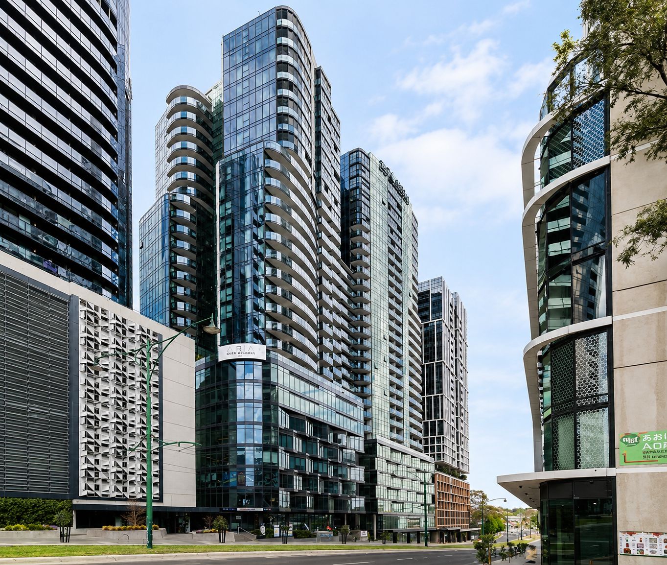 A modern high-rise building with a curved facade and multiple balconies.