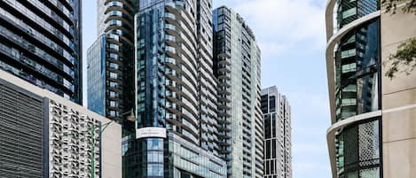 A modern high-rise building with a curved facade and multiple balconies.