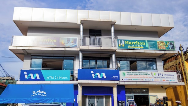 Un edificio de varios pisos con el cartel de Harriton Hotel, un cajero automático y una sucursal del banco J&M.