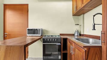 A compact kitchen with a built-in oven, microwave, and a gas stove.
