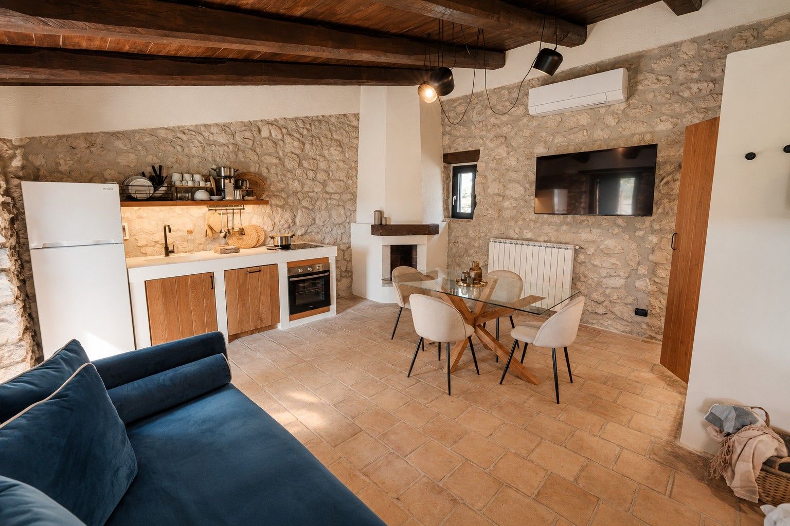 A compact living space with a kitchenette, dining area, and a sofa.