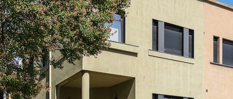Ein modernes, zweistöckiges Gebäude mit flacher Fassade, einer überdachten Einfahrt und einem befestigten Auffahrtsweg.