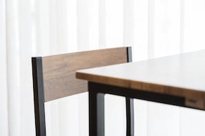 Ein Holzstuhl mit dunklem Gestell und ein Tisch mit heller Tischplatte.