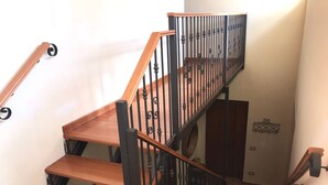 A wooden staircase with black railings and a handrail.