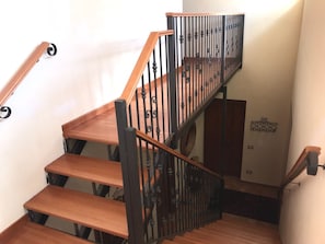 Eine Holztreppe mit schwarzen Geländern und Handlauf.