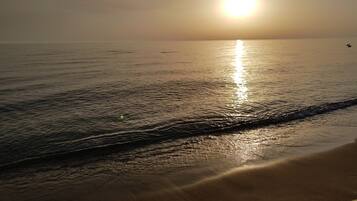 A beach with the sun reflecting on the water.