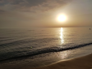 Una spiaggia con il sole che si riflette sull'acqua.