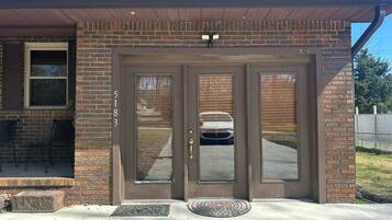 A two-story brick house with a front porch, a garage door, and a mailbox.