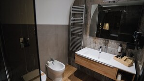 A modern bathroom with a bidet, a large mirror, and a vanity with a sink. - Harry's House Trani (Trani)