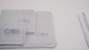 Neatly folded towels with 'Harry's House for Rent' branding, indicating a rental property. - Harry's House Trani (Trani)
