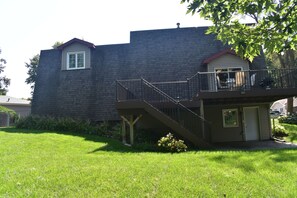 A two-story house with a front porch, a small deck, and a staircase leading to the upper level. - Spacious Lincoln Home - Sleeps 8 - Perfect for Families & Groups (Lincoln)