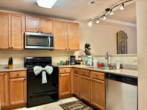 A kitchen with wooden cabinets, a microwave, a stove, a dishwasher, and a sink. - Unit 5402- FREE Attraction Ticket with EACH night Stay Including Dollywood (Pigeon Forge)
