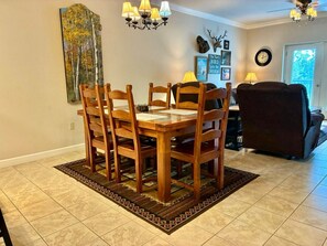A dining area with a wooden table and chairs, a patterned rug, and a chandelier. - Unit 5402- FREE Attraction Ticket with EACH night Stay Including Dollywood (Pigeon Forge)