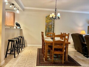 A dining area with a wooden table and chairs, a chandelier, and a painting on the wall. - Unit 5402- FREE Attraction Ticket with EACH night Stay Including Dollywood (Pigeon Forge)