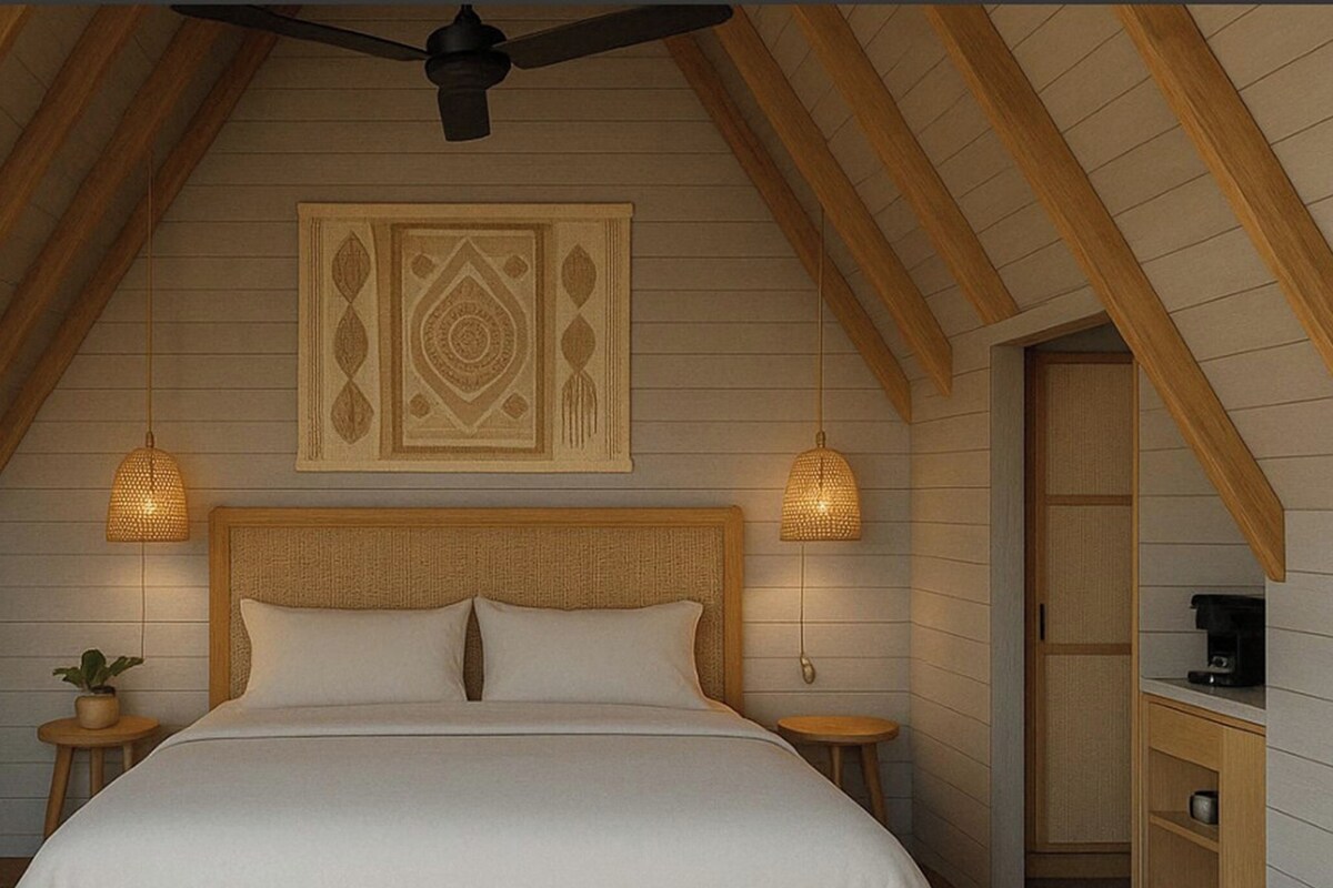 Un dormitorio con techo inclinado, una cama con ropa de cama blanca, dos lámparas de noche, un televisor montado y un elemento decorativo en la pared.