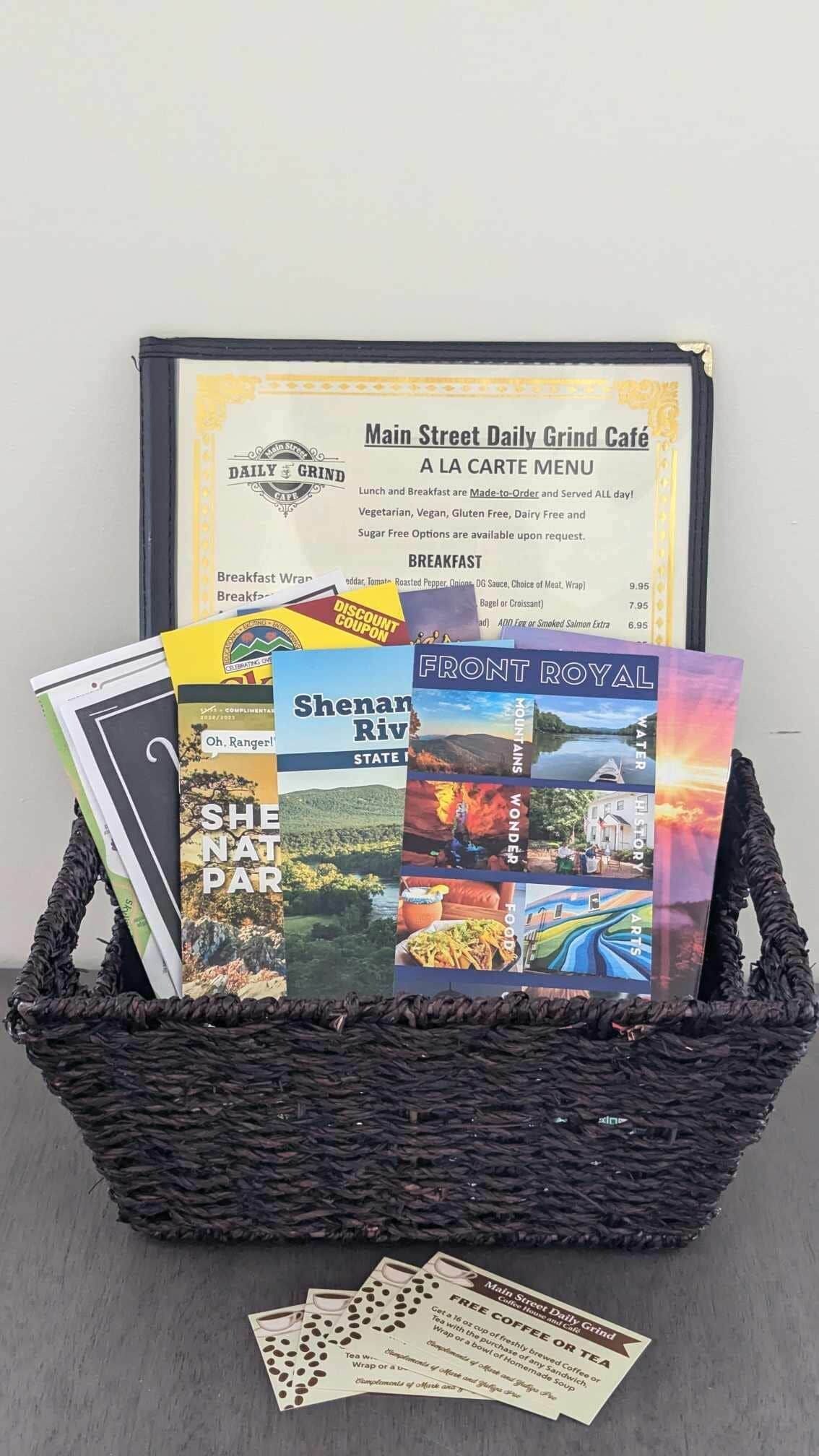 A basket containing books and a menu from Main Street Daily Grind Café.