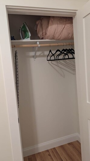 A closet with hanging space and a shoe rack.